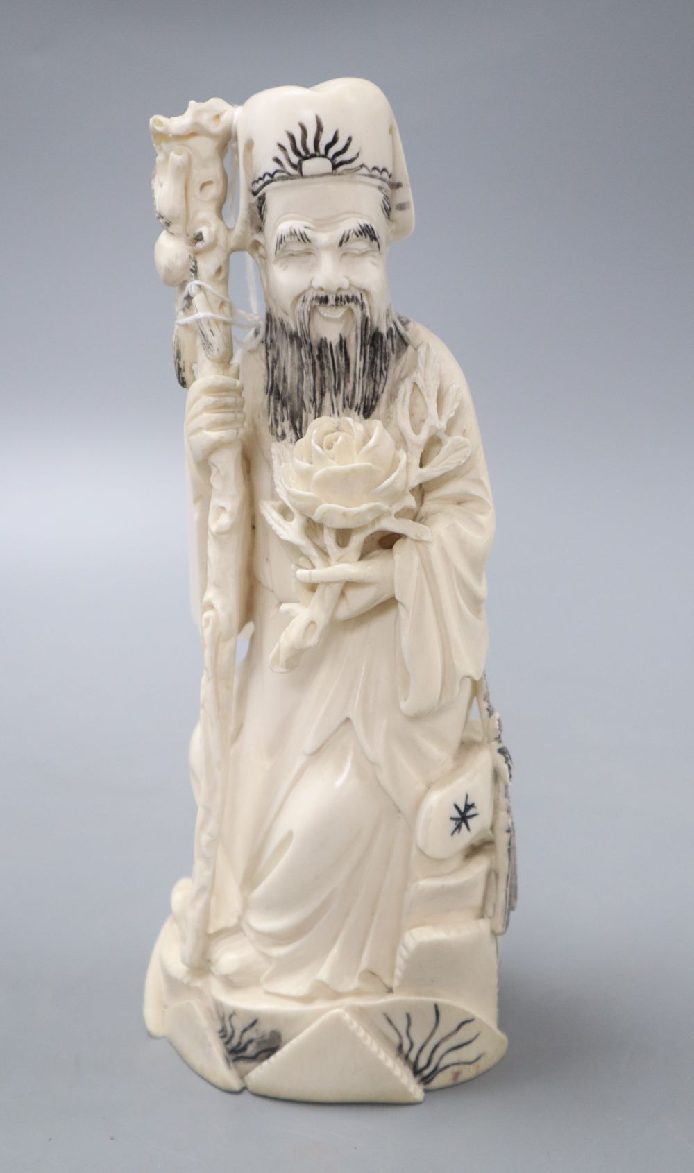 A Chinese ivory carving of a man holding flower